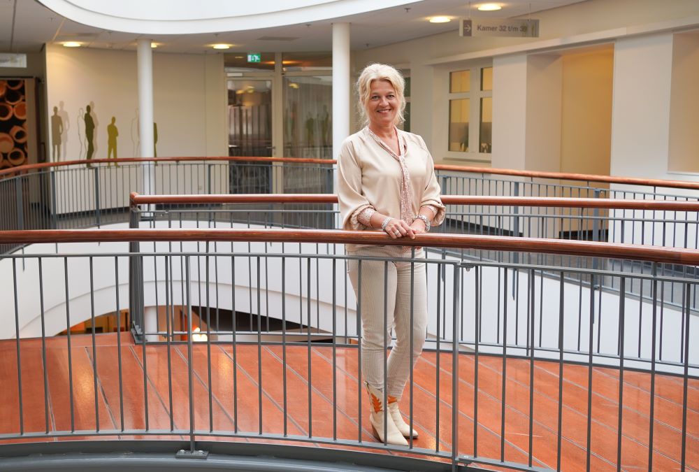 Annet Dijkstra staat op een balustrade, in de buurt van de poliklinieken. 