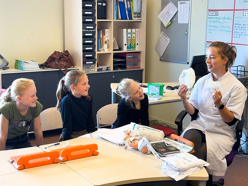 Dorian Blommaert houdt de basisschoolkinderen de verschillende formaten luiers voor