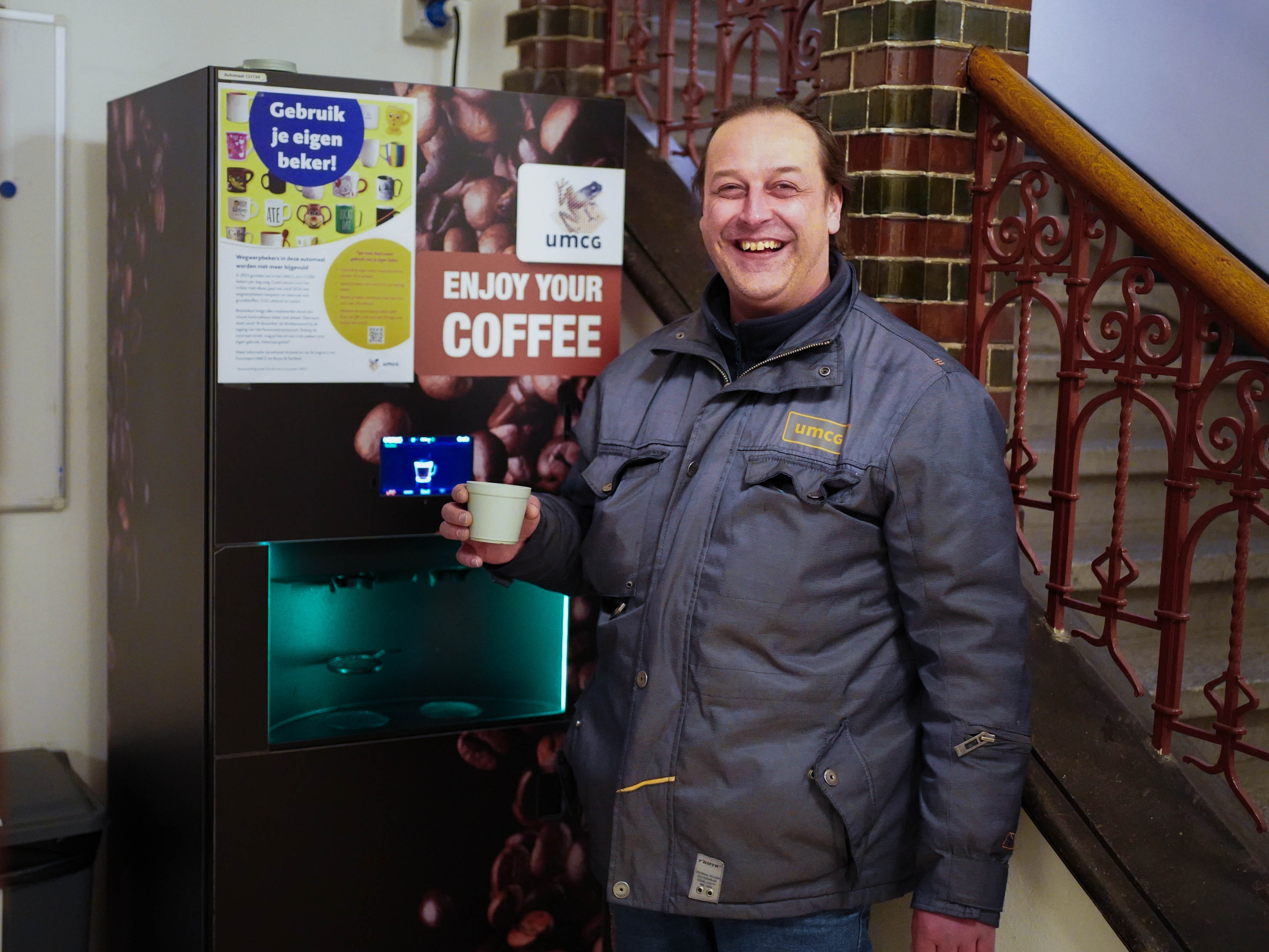 Terreinbeheerder Edwin Klaassens staat bij een koffieautomaat met zijn herbruikbare beker.